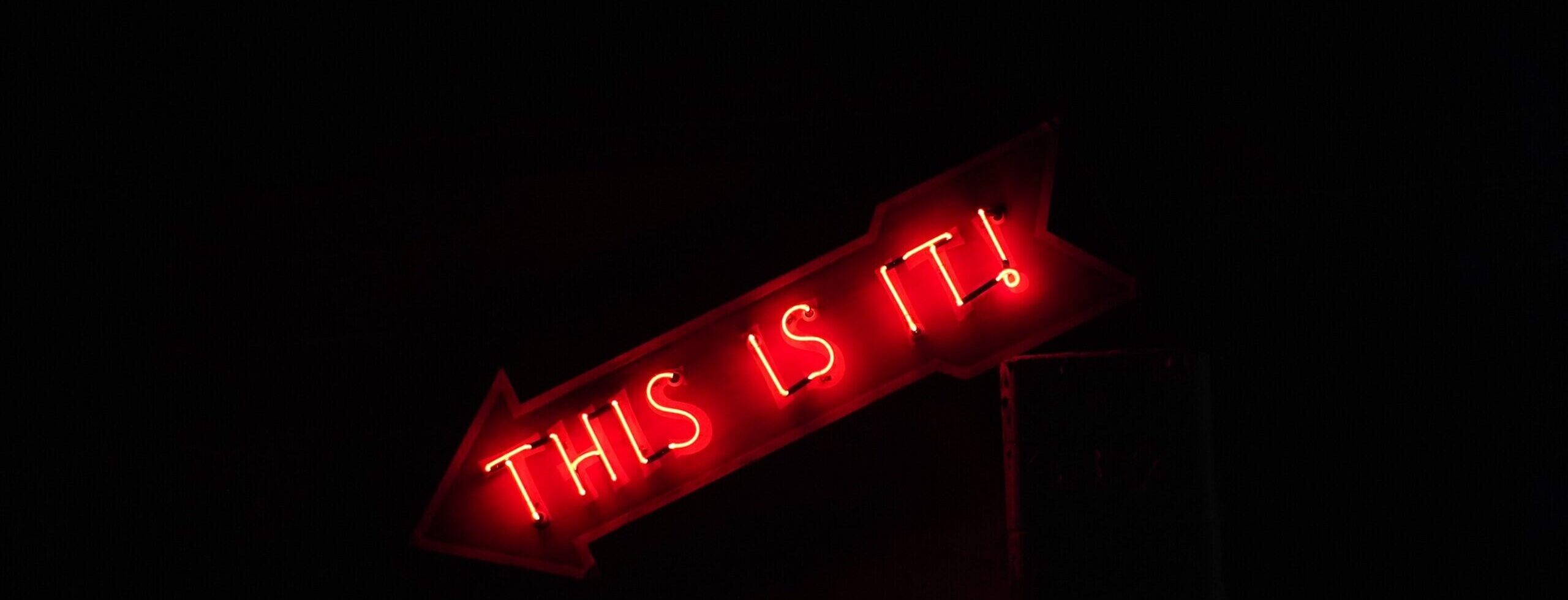 Neon sign reading 'This Is It!' - cropped - Rachel Writes email and e-newsletter writing service